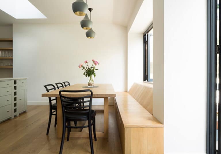 This stylish kitchen and outdoor seating area are joined by a bifold window and door