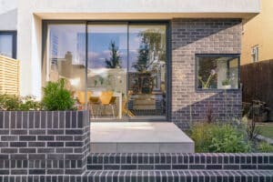 IDSystems theEDGE2.0 sliding doors - narrow 3-panel doors on modern grey brick extension