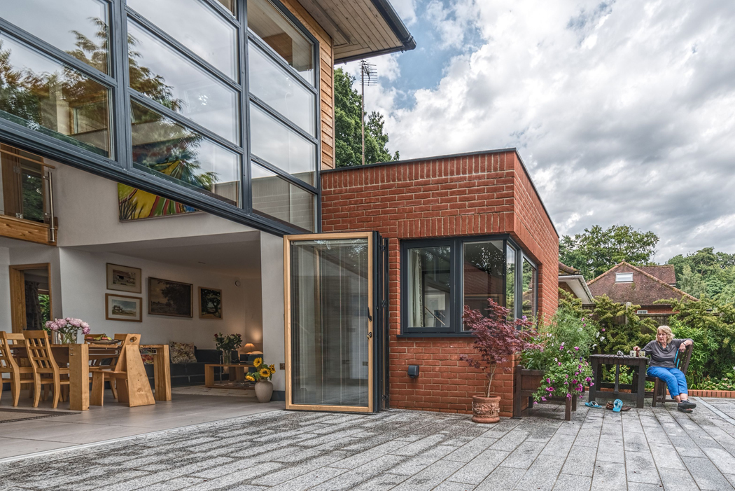 SF75c timber-clad aluminium bifold doors connect this house with patio and pool