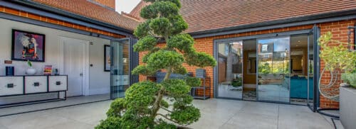 Red brick extension with vistaline slide & turn doors and courtyard garden