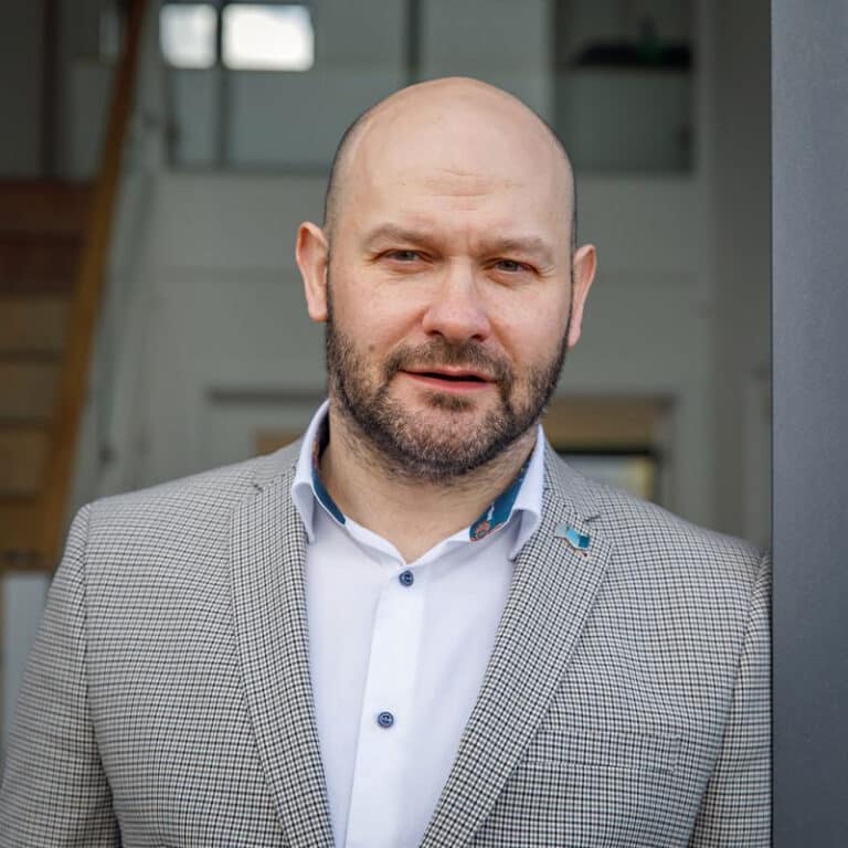 Edward Stobart, award-winning glazing specialist at IDSystems, wearing a light grey checked blazer and white shirt indoors.