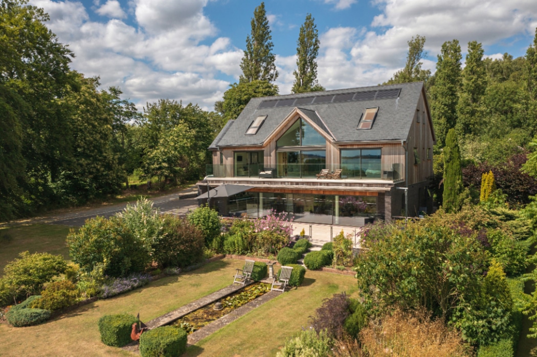 Contemporary riverside home in Essex featuring expansive 4 panel sliding glass doors flooding interior with natural light