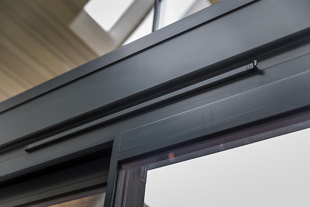 Close-up of trickle vents on modern sliding doors showing grey aluminium frame detail and ventilation mechanism.